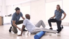Physiotherapists and patient using foam roller in rehabilitation - Powered by Shutterstock - Get 15% off with code: PIKWIZARD15