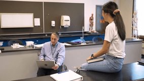 Science professor in wheelchair with laptop talking to college student - Powered by Shutterstock - Get 15% off with code: PIKWIZARD15