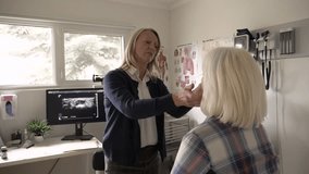 Female primary care physician examining patient in clinic exam room - Powered by Shutterstock - Get 15% off with code: PIKWIZARD15