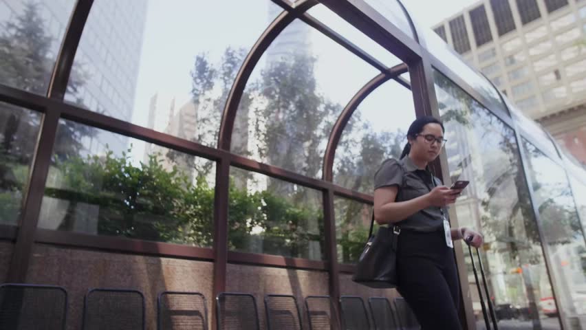 Slow motion of woman using phone at bus stop
