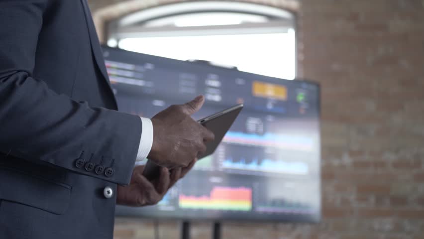 Businessman with digital tablet leading meeting at screen