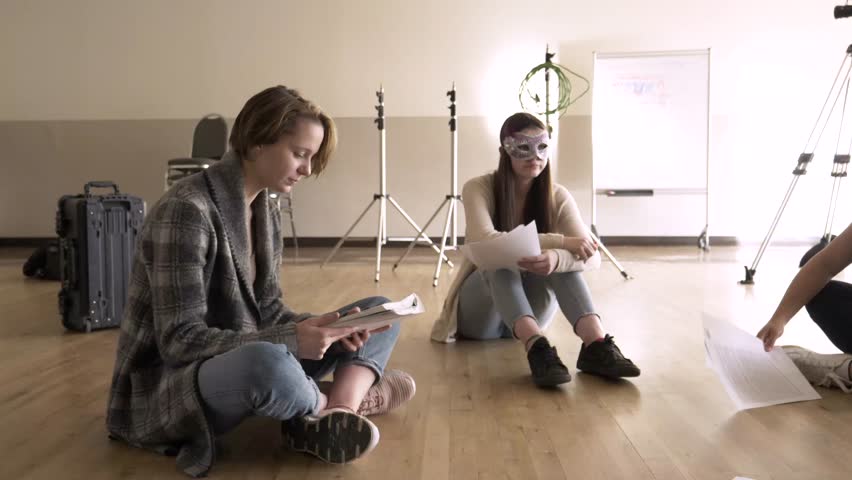 High school drama class rehearsing script on studio floor