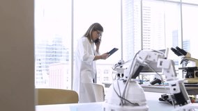 Female engineer with digital tablet talking on smart phone in laboratory - Powered by Shutterstock - Get 15% off with code: PIKWIZARD15