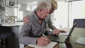 Senior couple using laptop at dining table - Powered by Shutterstock - Get 15% off with code: PIKWIZARD15