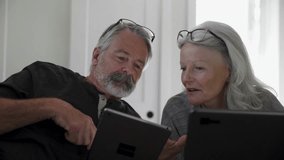 Laughing senior couple talking using digital tablet and laptop - Powered by Shutterstock - Get 15% off with code: PIKWIZARD15