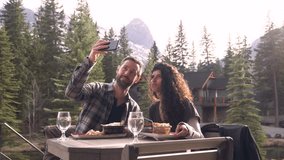 Slow motion of couple taking selfie on restaurant patio in front of mountain - Powered by Shutterstock - Get 15% off with code: PIKWIZARD15