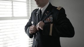 Male military officer putting on formal dress uniform jacket - Powered by Shutterstock - Get 15% off with code: PIKWIZARD15