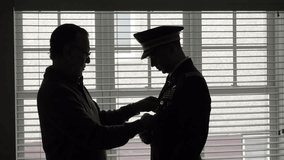 Proud father helping son with formal military uniform - Powered by Shutterstock - Get 15% off with code: PIKWIZARD15