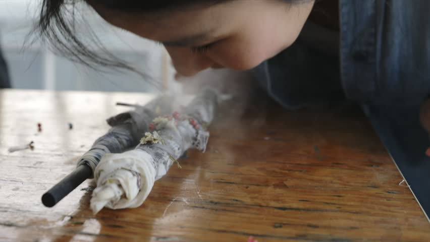 Women unrolling steaming bundles of dried flowers for paper making