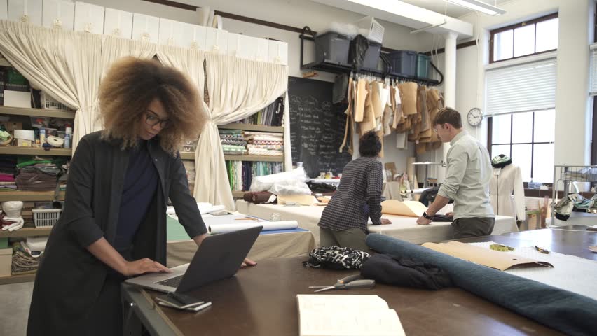 Female fashion designer working at laptop in studio