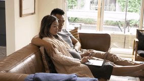 Pregnant couple with credit card shopping at laptop on sofa - Powered by Shutterstock - Get 15% off with code: PIKWIZARD15