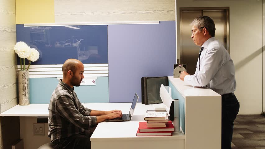 Businesssman talking to colleague working at reception