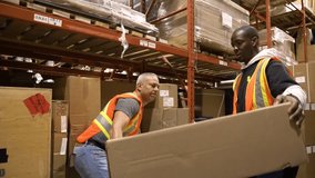 Male warehouse workers lifting large cardboard box together - Powered by Shutterstock - Get 15% off with code: PIKWIZARD15