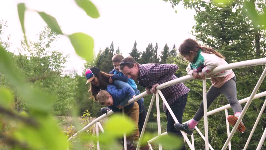 Slow motion of family on bridge over stream