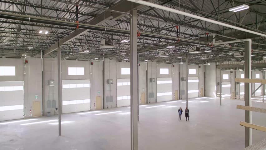 Female architects touring large empty warehouse loading dock - Powered by Shutterstock - Get 15% off with code: PIKWIZARD15