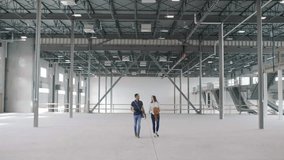 Young entrepreneurs touring large empty warehouse space - Powered by Shutterstock - Get 15% off with code: PIKWIZARD15