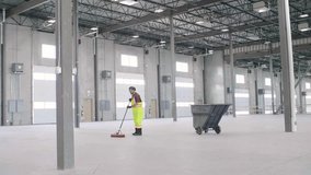 Male worker with broom cleaning empty warehouse loading dock - Powered by Shutterstock - Get 15% off with code: PIKWIZARD15