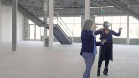 Female designers with VR goggles planning empty warehouse space - Powered by Shutterstock - Get 15% off with code: PIKWIZARD15