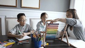 Mother using abacus home schooling children at dining table - Powered by Shutterstock - Get 15% off with code: PIKWIZARD15