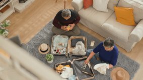 topview old asian senior couple packing cloth and stuff for a trip together,happiness asian old age retired mature adult enjoy arrange cloth together on floor at living room at home interior place - Powered by Shutterstock - Get 15% off with code: PIKWIZARD15