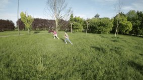 The video shows a boy and a girl playing in a park. They are both running and laughing, and they seem to be having a lot of fun. The boy is wearing a blue shirt and the girl is wearing a pink shirt