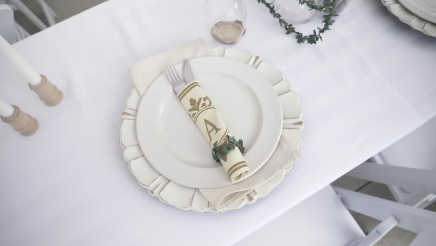 Monogram napkin and placesetting on white wedding reception table