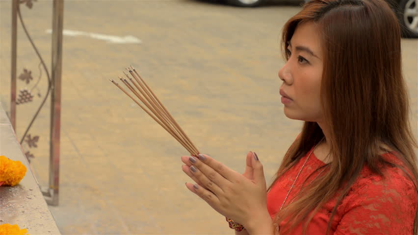 BANGKOK, THAILAND  - FEBRUARY 9, 2013: Thai woman praying at a shrine to Kwan