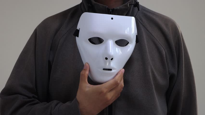 The chest of a man removing his white mask