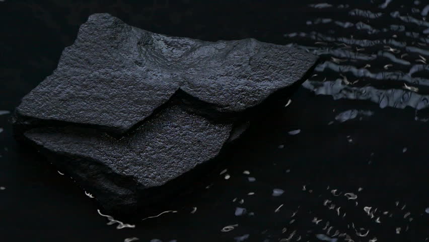 Slow motion water surface texture splashes, waves and ripples with black stone