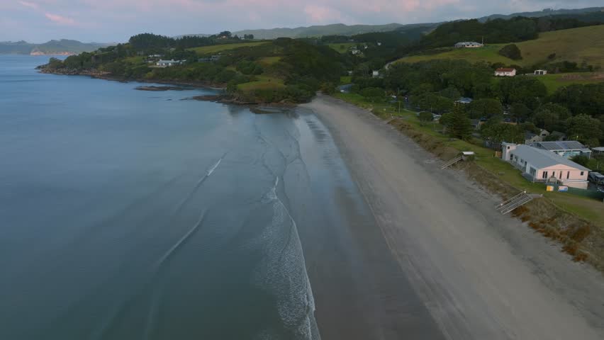 Aerial: Sandy beach coastline of Bream Bay and the rural town of Waipu, Northland, New Zealand.
