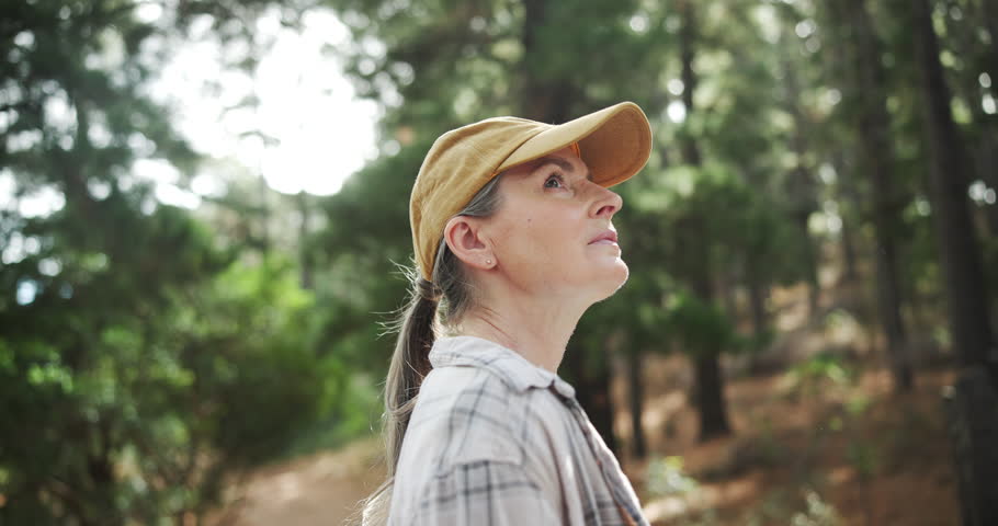 Hiking, forest or mature woman thinking in woods or nature for peace, trekking or outdoor adventure. Trip, relax or female hiker walking in park or Norway for exercise or wellness on holiday vacation