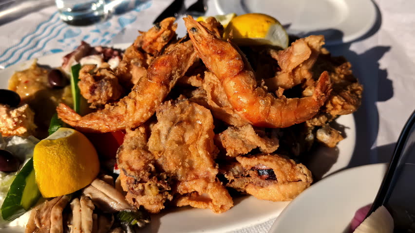 Delicious Seafood and Greek salad served and ready to eat. Close up.
