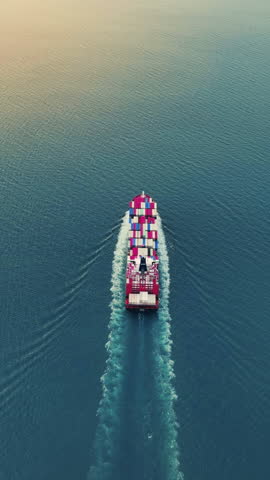 Stern of Cargo container ship carrying container and running out international container port customs shipyard sea port concept smart logistic service. Portrait video Container Ship.