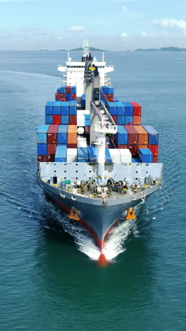 Front of Cargo container ship carrying container and running out international container port customs shipyard sea port concept smart logistic service. Portrait video Container Ship.
