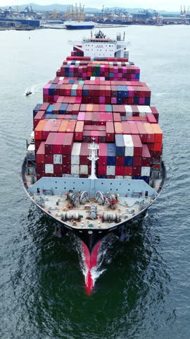 Front of Cargo container ship carrying container and running out international container port customs shipyard sea port concept smart logistic service. Portrait video Container Ship.
