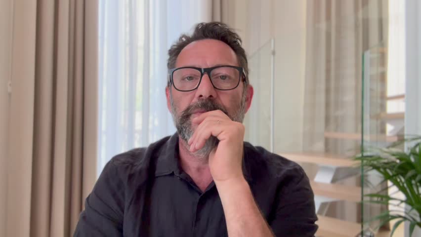 One man busy in videocall job interview or consulting web conference viewed from camera phone talking calm. Mature businessman therapist doctor manager speaking to clients or patients from home remote