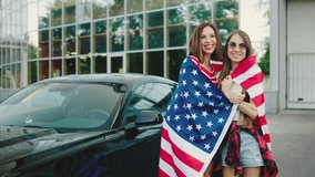 Two beautiful girls stands with an American flag against the background of a classic American car. American patriot women. A girls celebrates Independence Day of the United States of America - Powered by Shutterstock - Get 15% off with code: PIKWIZARD15