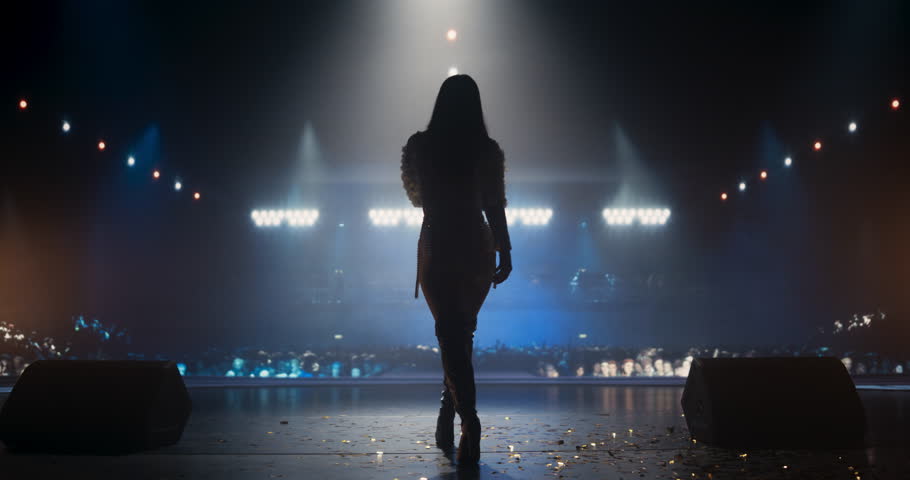 Music Contest: Back View of a Pop Music Artist Performing a Hit Song on Stage in Front of a Sold-Out Audience. Her Charismatic Stage Presence and Lyrics Electrify the Diverse Music Fans