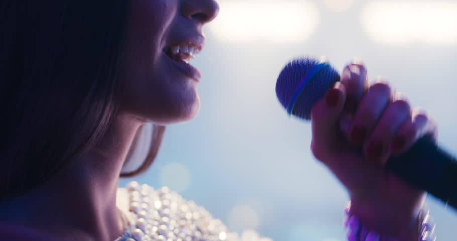 Lead Singer of a Pop Band Performing on a Live Concert Stage.Close Up Portrait of a Young Beautiful Female Singing a Hit Song into the Microphone. Artist Giving Her Energy to the Fans