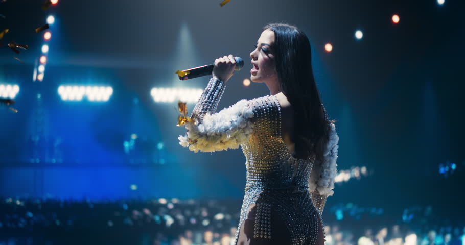 Pop Band Lead Singer Performs on Stage With a Mix of Emotions and Energy. Fans Watching a Powerful Music Show by a Talented Female Artist. Mesmerizing Confetti Falling on a Beautiful Female on Stage