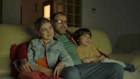 Father With Son and Daughter Watching Movie at Home in Living Room at Night. Togetherness Parenthood. Happy Smiling Family With Children Sitting On Sofa In Living Room Evening Watching TV Together.  - Powered by Shutterstock - Get 15% off with code: PIKWIZARD15