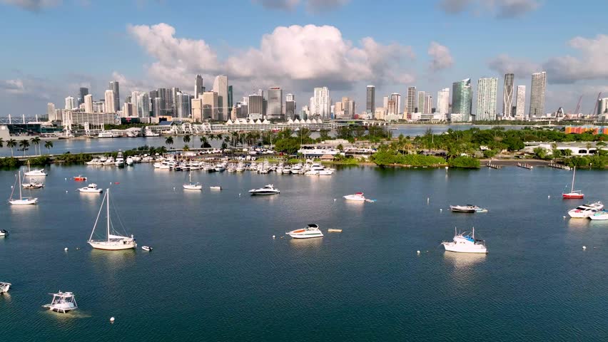 aerial push over boat in bay leading into the miami florida skyline