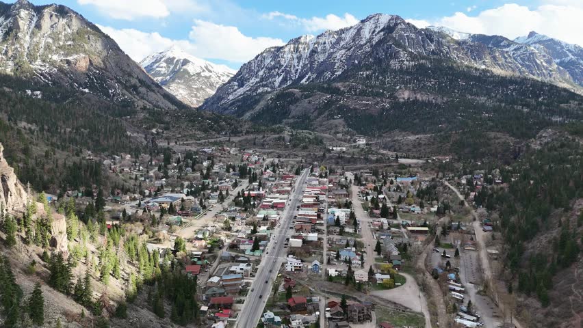 Aerial View of Small Mountain Town, multiple houses and buildings with snowcapped mountains in background, Ouray Colorado