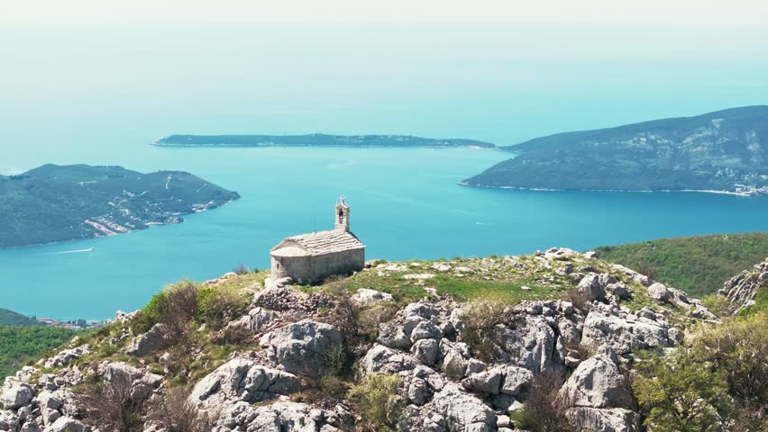 Picturesque stone chapel situated in a remote, elevated location with stunning natural surroundings.