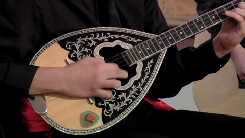 Artist playing bouzouki, close up