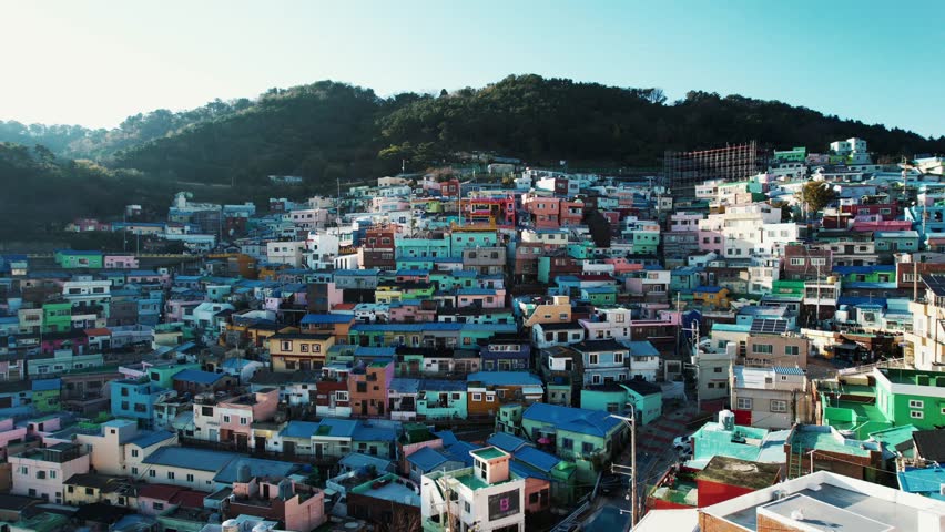 an aerial view of Gamcheon Culture Village in Busan, Korea. It showcases colorful houses densely packed on steep hills with winding roads.
