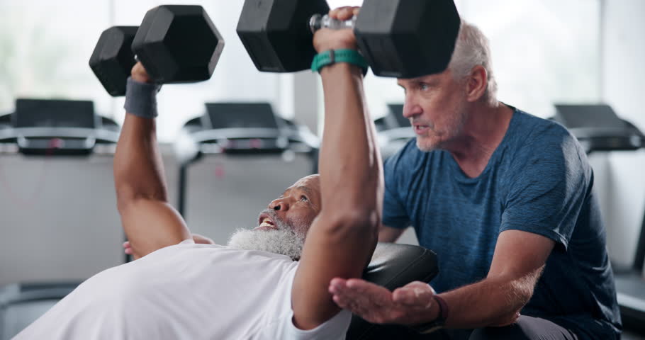 Gym, dumbbells and man with personal trainer, bodybuilder and wellness for body and healthy. Workout, exercise and mature people in club with equipment, training and fitness, motivation and muscle