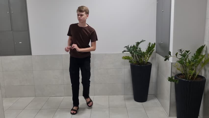 Teenage Boy Dancing in Modern Hallway. Youthful Energy and Spontaneous Joy