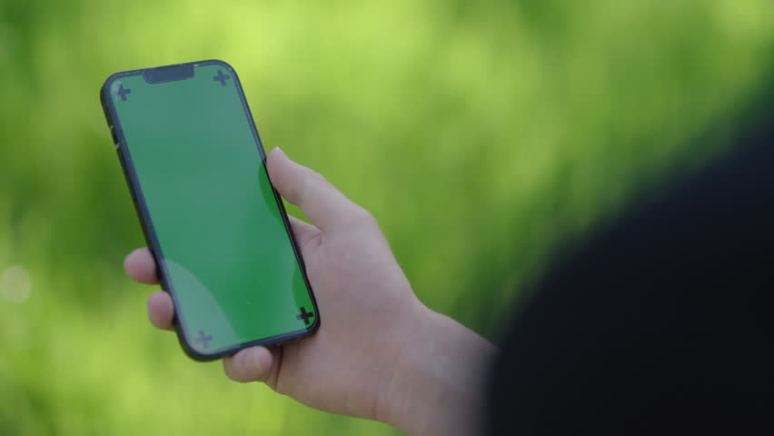 Young man using his phone on a sunny summer day in the forest