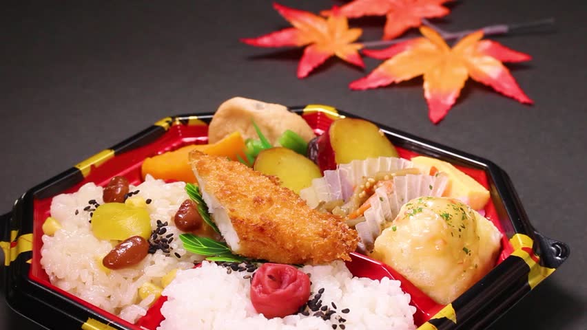 Autumn colourful lunch box on black background rotating